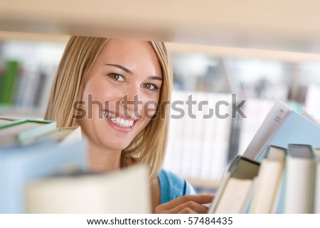 Student in library - cheerful woman look through bookshelf, hold book