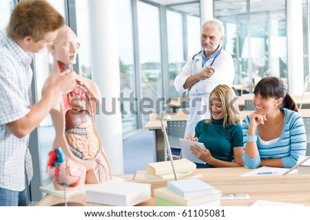 University - medical students with professor and human anatomical model in classroom
