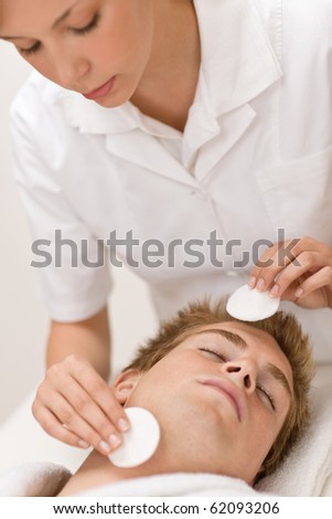Male beauty - man at luxury spa treatment receiving facial care