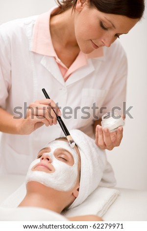Woman at luxury spa beauty treatment getting facial mask