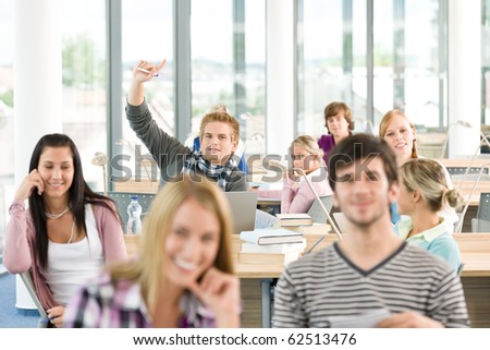 High school student raising hands in classroom
