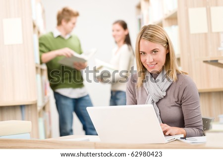 High school library - female student with laptop and book