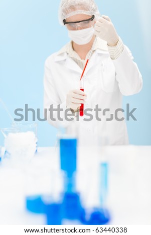 Flu virus vaccination research - woman scientist in laboratory testing, holding test tube