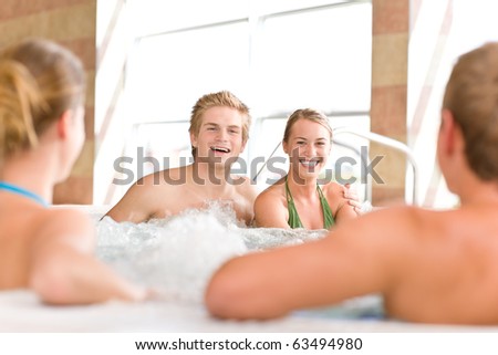 Swimming pool - young happy couple relax in hot tub