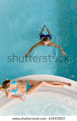 Top view - young couple relax in swimming pool sitting at bubble bath