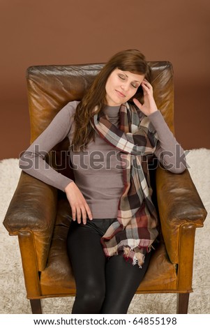 Beautiful brunette Hispanic fashion model on brown leather antique armchair