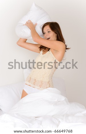 PIllow fight - young woman in bed having fun