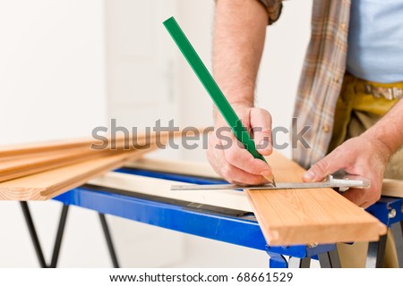 Home improvement - close-up of handyman measure wooden floor