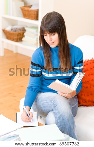 Teenager girl home - student write homework sitting at table