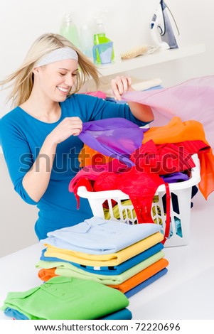 Laundry - woman folding clothes home, housework
