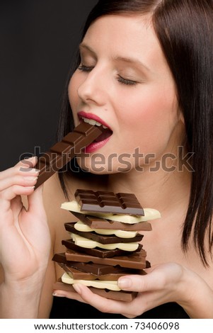 Chocolate - portrait of healthy woman eat sweets on black background
