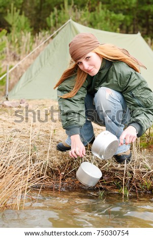 Camping tent happy woman washing dishes in water stream