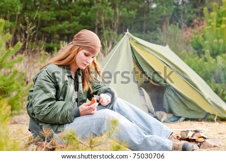 Camping happy woman nature tent cut sausage by fire