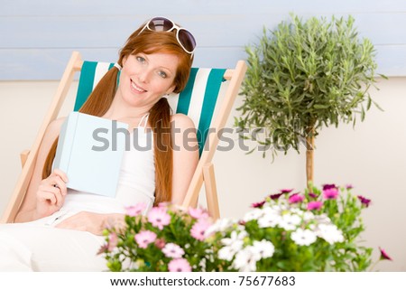 Summer terrace red hair woman relax in deckchair garden