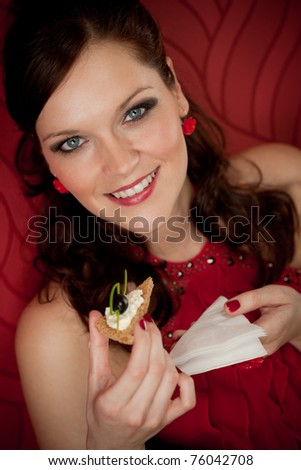Cocktail party woman eat appetizer evening dress red background