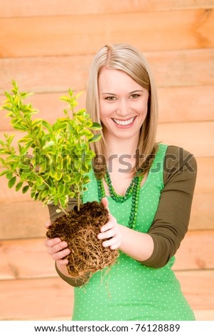 Portrait happy woman hold green plant spring gardening