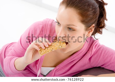 Fitness woman eat granola bar sportive outfit in gym
