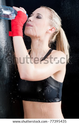 Boxing training woman pour water on face hold punching bag