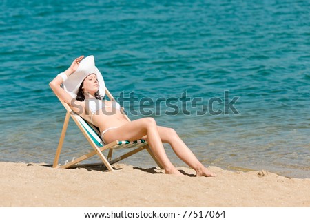 Summer young woman sunbathing in bikini on beach