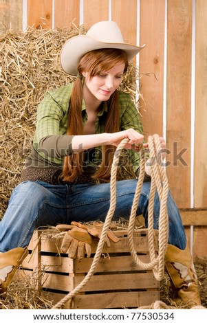 Young cowgirl western country style sitting in barn
