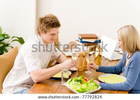 Happy couple enjoy wine eat salad in kitchen