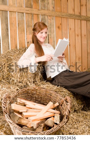 Young romantic redhead woman read book sitting in barn