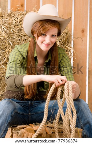 Young cowgirl western country style sitting in barn