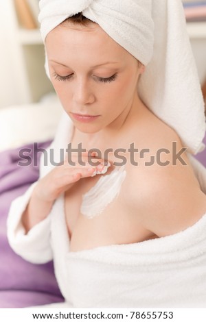 Young student girl apply body cream lotion on her chest