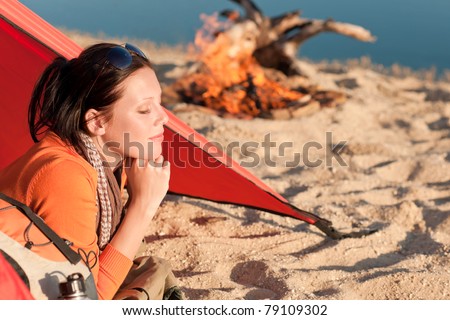 Camping happy woman relax lying in tent by  campfire