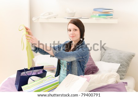 Young happy attractive girl unpack shopping bags in student apartment