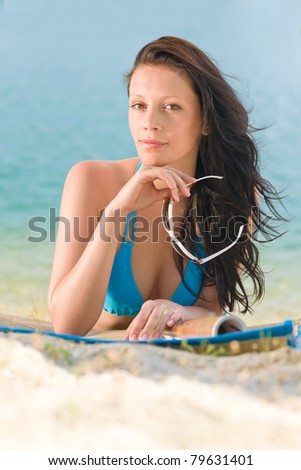 Happy woman in blue bikini read magazine sunny day