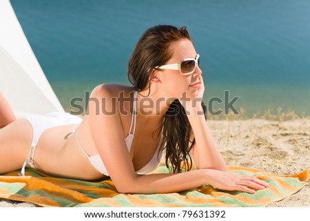 Summer beach stunning woman sunbathing in bikini parasol background