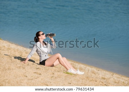 Summer beach active woman drink water bottle in fitness outfit