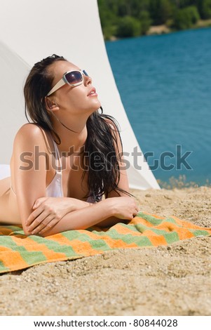 Summer beach stunning woman sunbathing in bikini parasol background