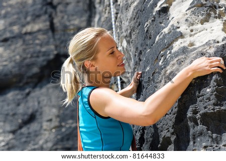Rock climbing blond woman on rope  sunny day