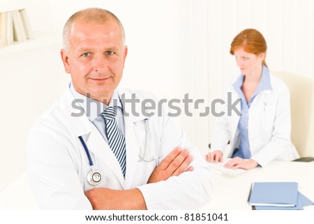 Medical senior doctor male with professional young female colleague office
