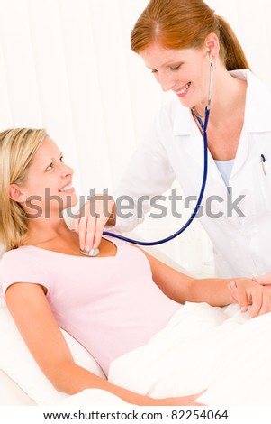 Medical professional doctor stethoscope examine woman patient lying in bed