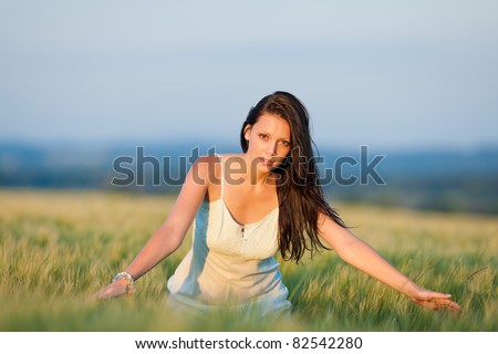 Summer sunset beautiful brunette woman walk in wheat corn field