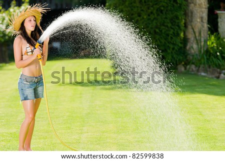 Summer garden grass woman play with water hose sunny day