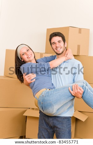 Moving new home young happy man holding woman cardboard boxes