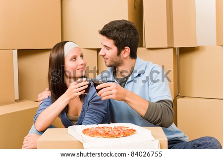 Moving into new home young happy couple have pizza lunch