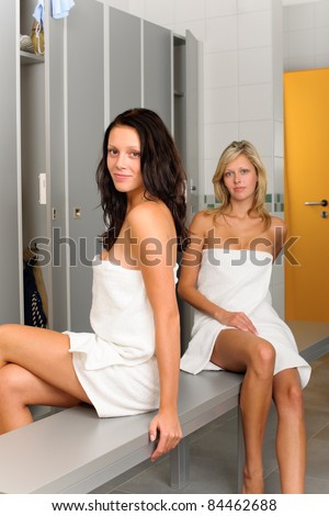Locker room two relaxed women attractive wrapped in white towel