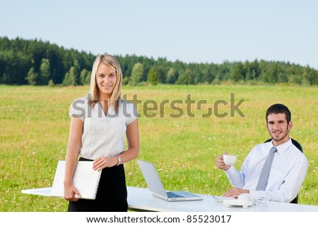 Young businessman in sunny nature with folders and female colleague