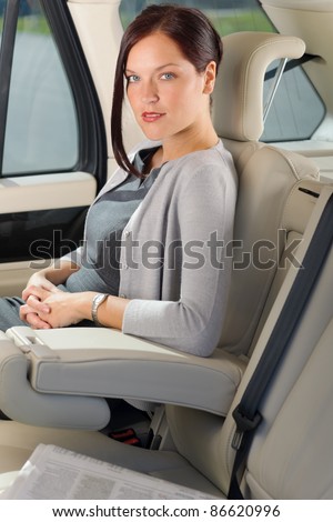 Executive businesswoman sitting in car leather backseat wear suit