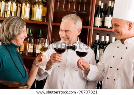 At the bar - senior barman , chef and woman having drink
