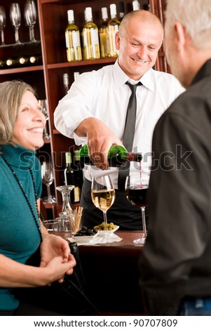 Wine bar happy senior people having drink smiling barman