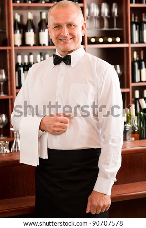 At the bar - senior barman standing in front of counter