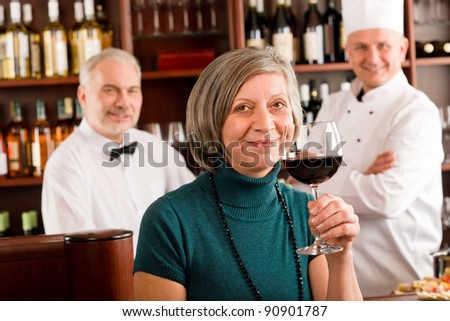 Restaurant manager happy taste glass of red wine in bar