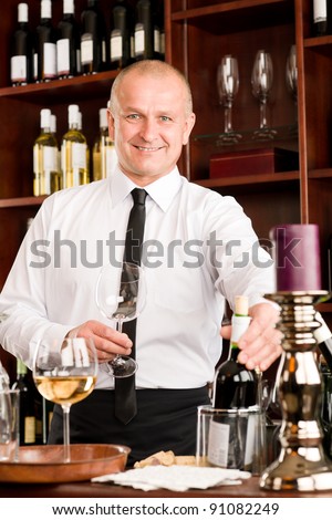 At the bar - waiter hold bottle white wine in restaurant
