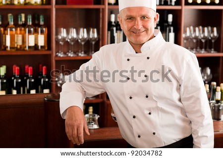 Chef cook confident professional posing in restaurant leaning over counter